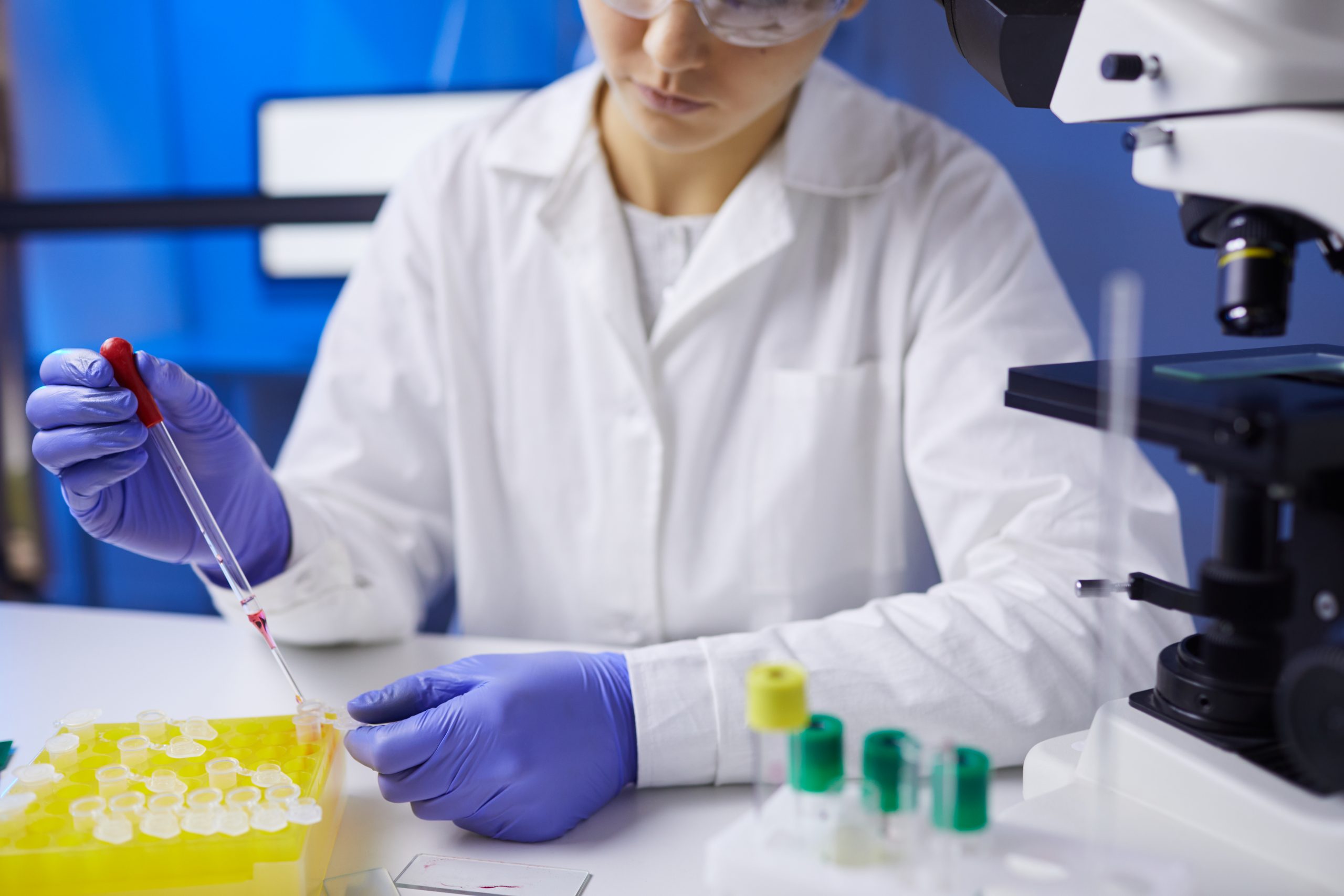 Close up of unrecognizable young woman preparing blood samples while working on research in medical laboratory, copy space